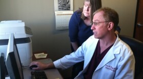 At Universal Pain Management, Dr. Francis Riegler confers with Trudy Roberts, the clinic's nurse practitioner, over a patient's record of prescription drug purchases.