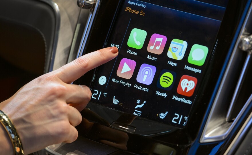 A visitor presses the new Apple's CarPlay touch-screen commands in March 2014 inside the Volvo Estate concept car displayed at the Swedish carmaker during the press day of the Geneva Motor Show in Geneva. Rumors this week suggested that Apple wants to move on to building its electric car, a historically perilous venture.