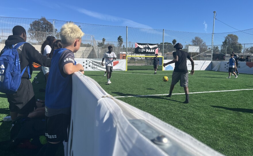 A group of young kids watch players on the field from the sidelines at Adam R. Scripps Street Soccer Park, Feb. 25, 2026.