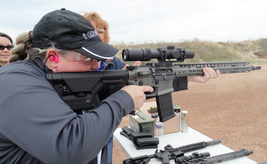 Robyn Sandoval, executive director of A Girl & A Gun, aims a rifle.