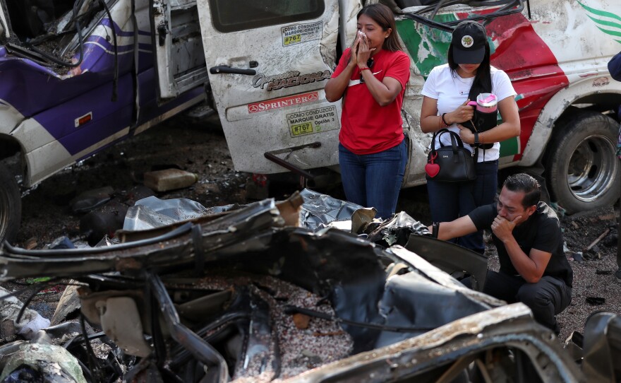 Relatives of victims pay respects at the site of an attack on the Pan-American Highway in Cajibio, Colombia, Sunday, April 26, 2026, where at least a dozen people were killed in an attack authorities blamed on dissident groups of the former FARC rebels.