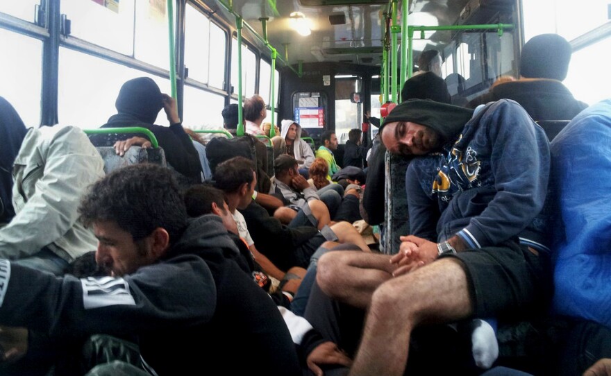 Exhausted refugees sleep on a bus to Vienna from Budapest. The bus was so crowded that Omar couldn't find a seat, and he crouched on the floor.