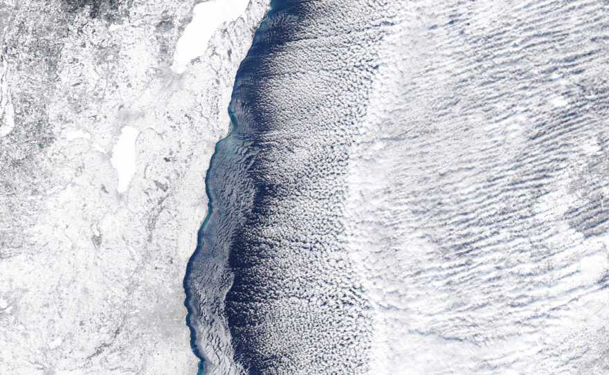 Lake Michigan, now partially frozen, as snow and clouds blow over.