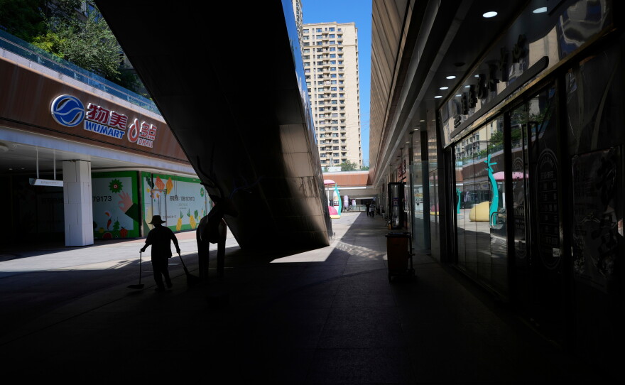 A worker collects trash in a partially shuttered Evergrande commercial complex, on the day Hong Kong Stock Exchange delisted the Chinese property developer China Evergrande, in Beijing, China, Aug. 25, 2025.