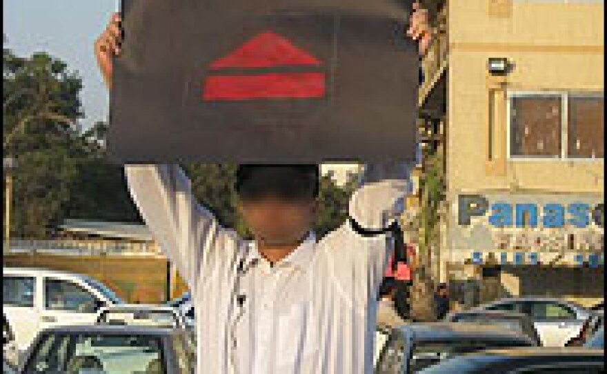 A flash protester calls for the ejection of President Musharraf at a supermarket in Karachi last week. (Image obscured by NPR to protect the individual.)