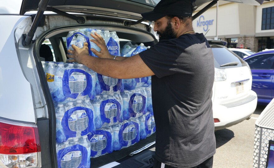 Rajwinder Singh, a gas station/convenience store owner, loads the 15 cases of drinking water he purchased from a Kroger grocery store into his vehicle on Tuesday in Jackson, Miss. Parts of the city were without running water Tuesday after recent flooding worsened problems at one of the city's main water-treatment plants.