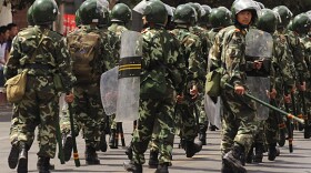 Riot police patrol a street in Urumqi in China's far western Xinjiang province on Monday following deadly riots.