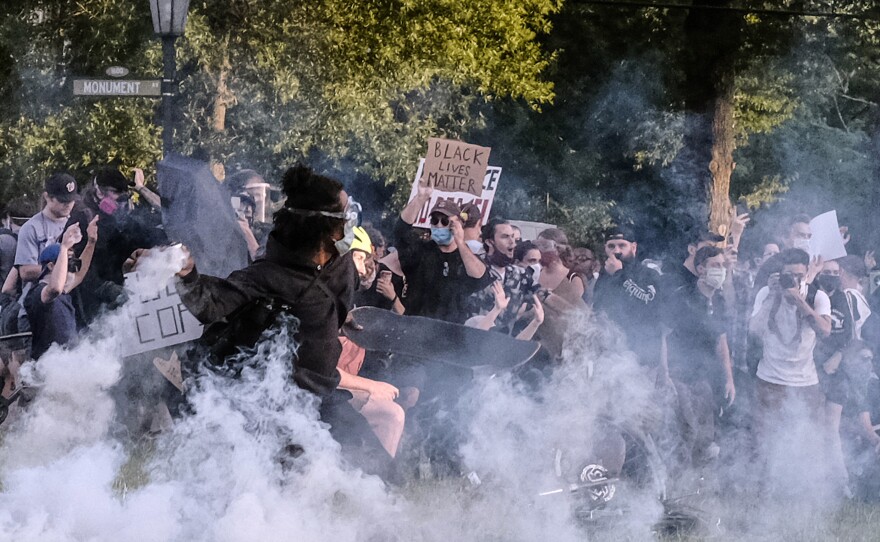 Protesters participating in a peaceful demonstration react to being hit by Richmond Police with tear gas and pepper spray on Monument Avenue at the Robert E. Lee statue on June 1, about 30 minutes before the city's curfew.