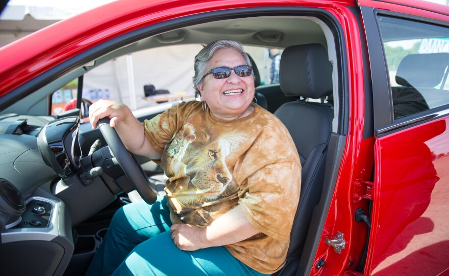 Mary Serrano test drives an electric Chevy Spark at a smog repair event May 30 in Stockton, Calif. The event connected drivers of high-polluting cars with cap-and-trade funds to help purchase cleaner cars — part of California's 2006 law to combat global warming. Gov. Jerry Brown says that those existing greenhouse gas emission goals aren't enough.