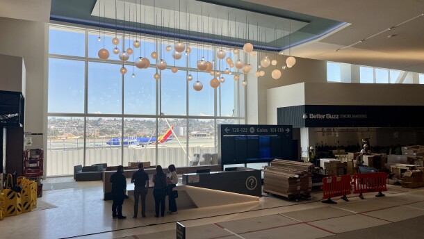A plane passes by on the runway, seen through the windows at San Diego International Airport's New Terminal 1, Aug. 27, 2025.