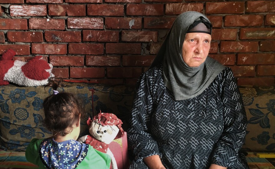 Suad Thabet sits with her granddaughter Sandy at home in Abu Qarqas, Egypt. Thabet was attacked by a mob last year after one of her sons was accused of having an affair with a Muslim woman.