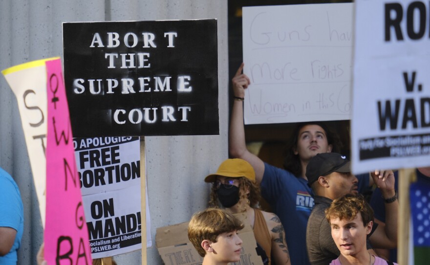 Some protesters sought to contrast the ruling allowing states to restrict access to abortion with recent rulings limiting states' abilities to regulate firearms in downtown San Diego on Friday, June 24, 2022.