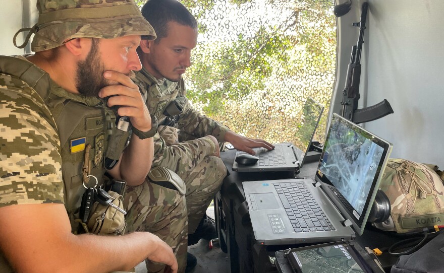 Sacha and one of his drone team colleagues monitor a live video feed from a drone they're flying over a Russian-occupied part of Ukraine.