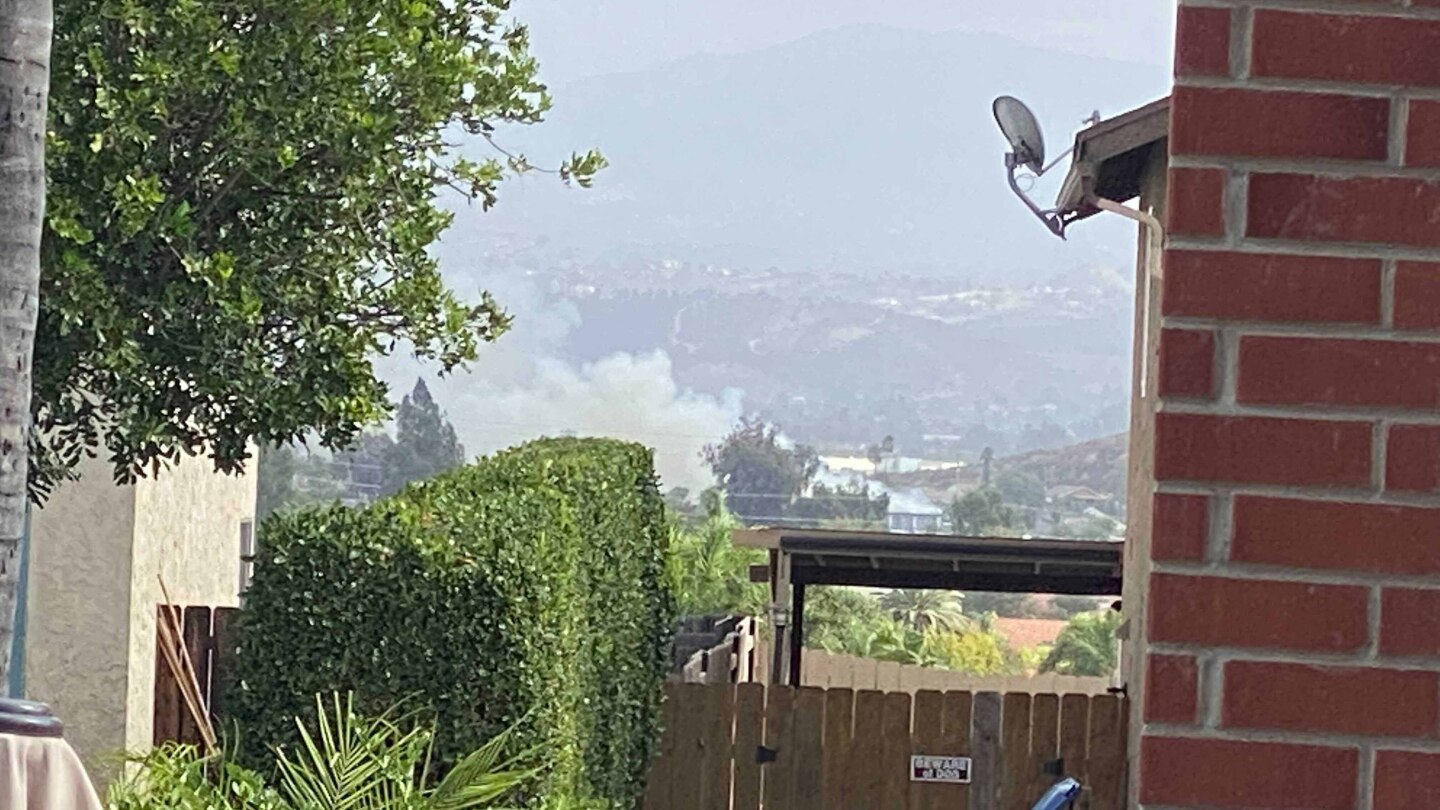 Smoke is seen from a backyard from a small plane crash near Santana High School in Santee, Oct. 11, 2021.