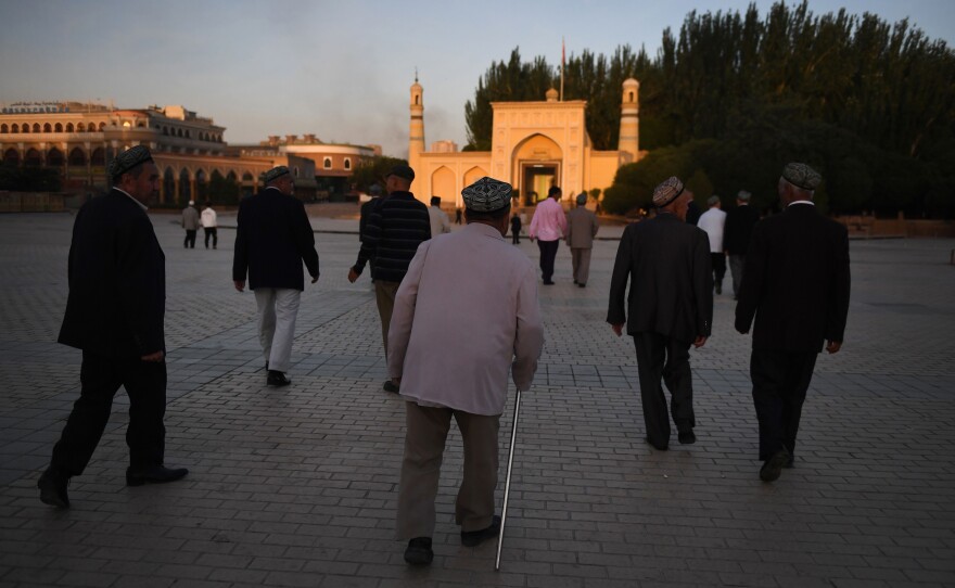 Uighur men walk towards the Id Kah mosque to attend prayers marking the end of Ramadan, in Kashgar in China's northwest Xinjiang region, in 2019.