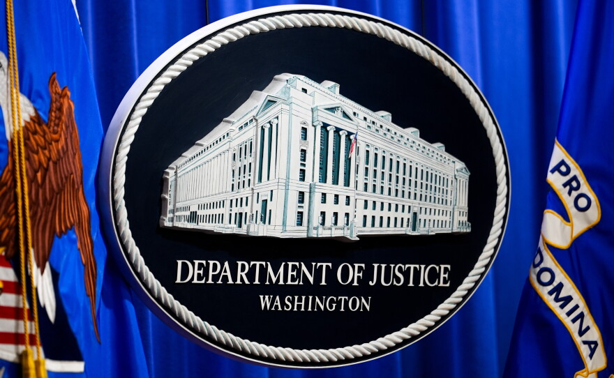 The U.S. Department of Justice logo is before a news conference, Monday, May 4, 2026, in Washington.