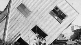 A house tipped on its side, with several boys standing in front, after the Great Galveston Storm in Texas. The storm remains the worst natural disaster and the worst hurricane in U.S. history.