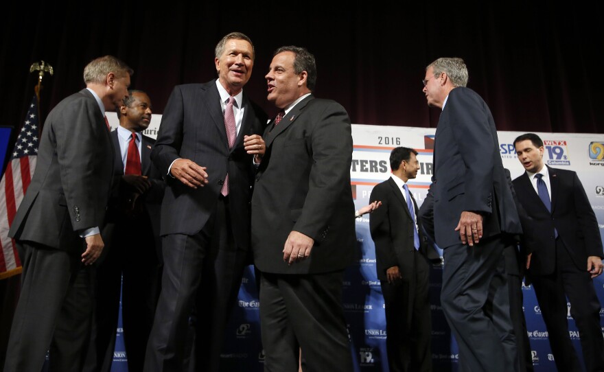 Republican presidential candidates, from left, Lindsey Graham, Ben Carson, John Kasich, Chris Christie, Bobby Jindal, Jeb Bush, Scott Walker and Rick Santorum speak among themselves after a forum Monday, Aug. 3, 2015, in Manchester, N.H.