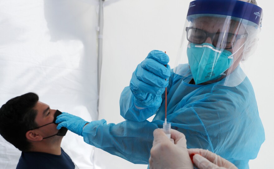 Dr. Glenn Lopez administered a standard test for the coronavirus to Daniel Contreras at a mobile clinic in South Los Angeles last week. Though highly accurate, such tests can take days or more to process.