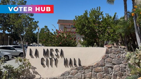 The Voter Hub logo is overlayed on the top left over a photo of a sign of La Mesa City Hall located on Allison Avenue. Photo taken Sept. 24, 2025.