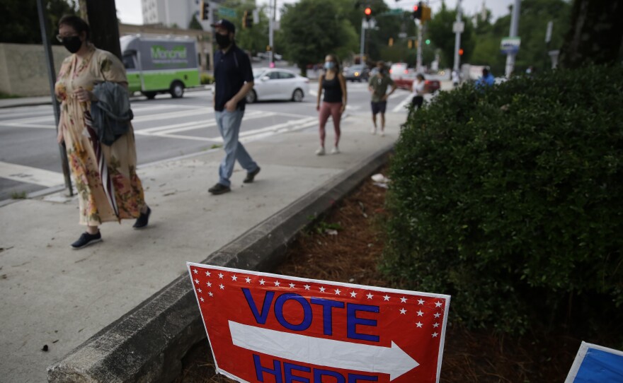 People wait in line to vote in Georgia's primary election in Atlanta on Tuesday. Long lines and equipment problems are hampering the twice-delayed primary.