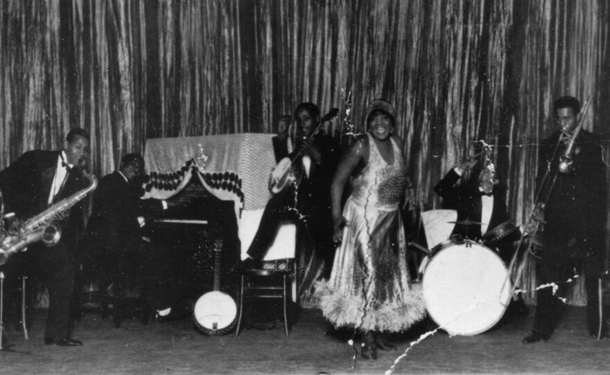 Bessie Smith on stage with her band in Philadelphia, Penn. Smith infused her performances with glamour whether she was performing in cities or for rural audiences in settings that evoked minstrelsy.
