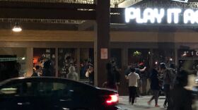 A crowd gathers outside Play It Again Sports in the La Mesa Springs Shopping Center, May 30, 2020.