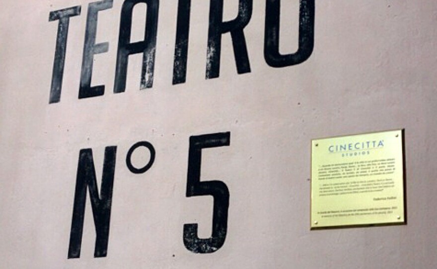 A plaque featuring a quote from Federico Fellini adorns his favorite studio: "When I'm asked what city I'd like to live in, London, Paris or Rome, to be honest my answer is Cinecittà. Cinecittà Studio 5 is actually my ideal place, this is how I feel before an empty stage, a place to be filled and a world to be created."