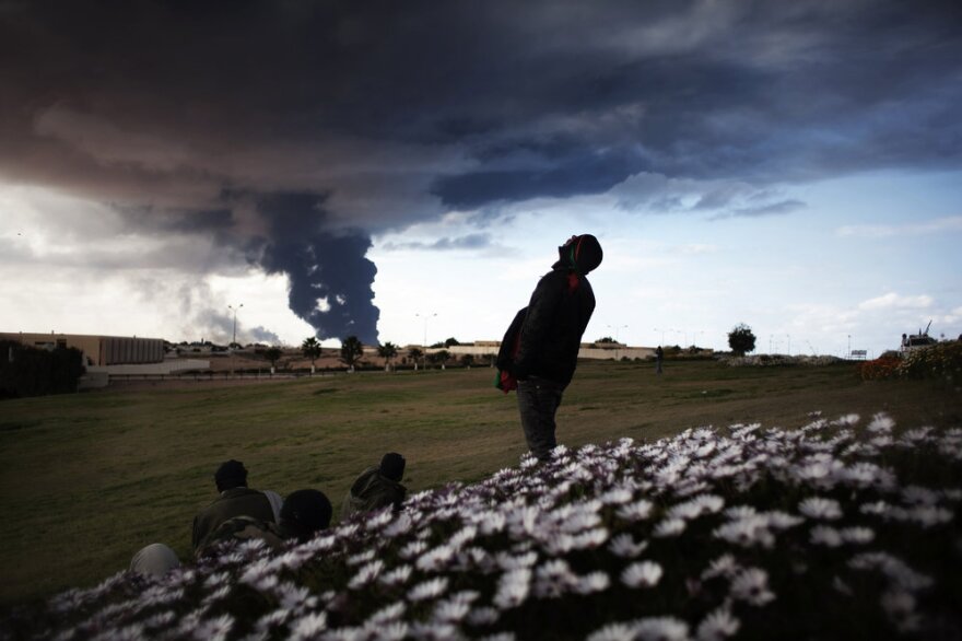Libyan rebels watch smoke rising from an oil pipe just outside the town of Ras Lanuf, where many anti-regime fighters retreated after artillery and airstrikes from government troops Wednesday.