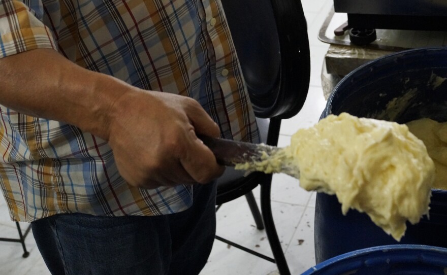 Abdelali Sheikh's family has been in the smen business for 150 years. He operates a storefront in Smen Square that's lined with blue plastic barrels and outfitted with brass scale to measure out his products.