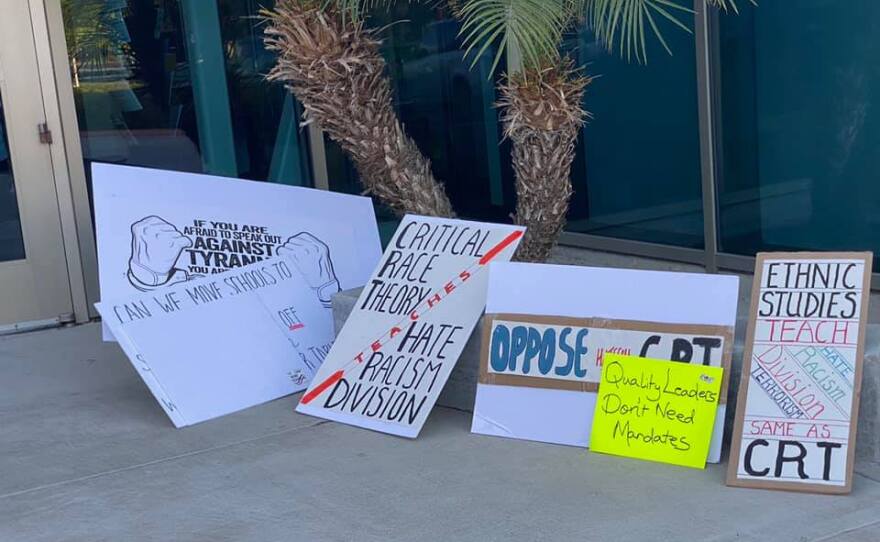 Signs protesting 'critical race theory' sit on the ground outside the Poway School District offices. September 9, 2021.