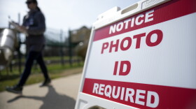 A voter walks past a sign requiring a photo ID at a polling location in Mount Holly, N.C., on March 5, 2024. North Carolina is one state deciding a voter ID ballot measure this year.