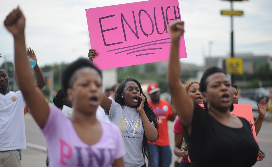 Protesters walk on West Florissant Avenue in Ferguson, Mo., on Tuesday. Protests have been going on for more than a week after the police shooting of unarmed teen Michael Brown.