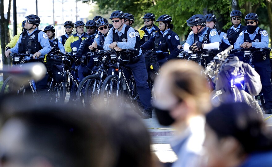 Chicago Police officers watch demonstrators on Lake Shore Drive during a protest in honor of George Floyd, in June, in  downtown Chicago. A new report says police were unprepared and ill-equipped to handle the summer's protests.