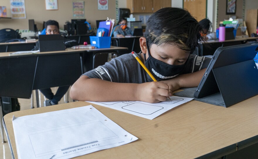 A student wears a face mask while at the Post Road Elementary School in White Plains, N.Y., last October. A recent study found the number of children contracting coronavirus is on the rise.