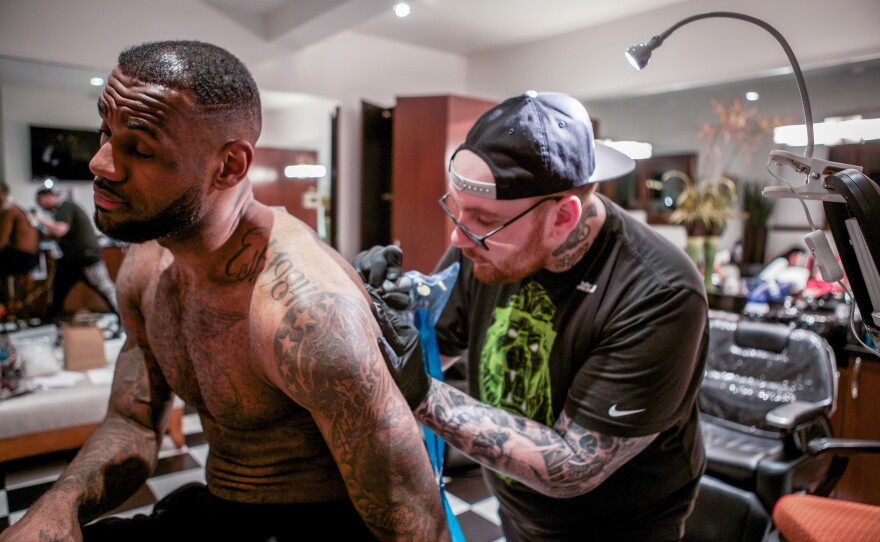 Tattoo artist Keith "Bang Bang" McCurdy works on NBA star LeBron James.
