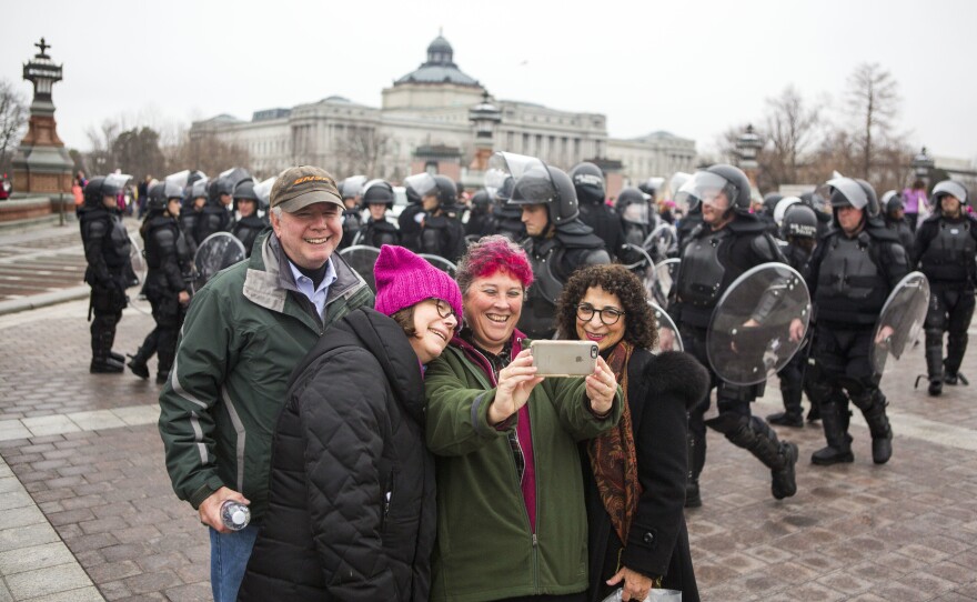 Protesters take a selfie with the police as a backdrop outside the U.S. Capital during the Women's March on Washington.