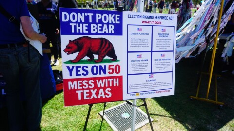 Supporters of a plan to redraw California's congressional districts ahead of the 2026 general election display a sign outside of the San Diego County administration building on Sep. 1, 2025 in San Diego, Calif.