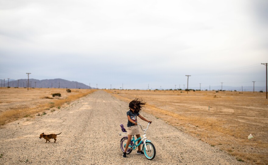 <strong>Salton City, near California's Salton Sea:</strong> Lizette plays on her bicycle as strong winds are blowing across her neighborhood. Little water enters the area and the water that does enter is all agricultural run off laced with pesticides and fertilizers. As the lake shrinks it exposes sand and dust that blows into the air exposing people living nearby to PM10 particulate dust.