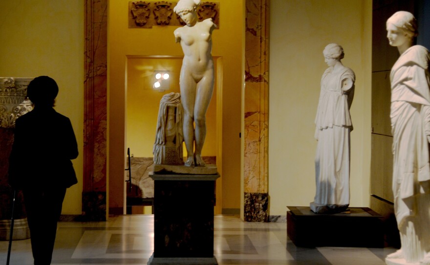 A picture taken on Tuesday shows a visitor walking past an ancient Roman marble statue at Rome's Capitoline Museum.