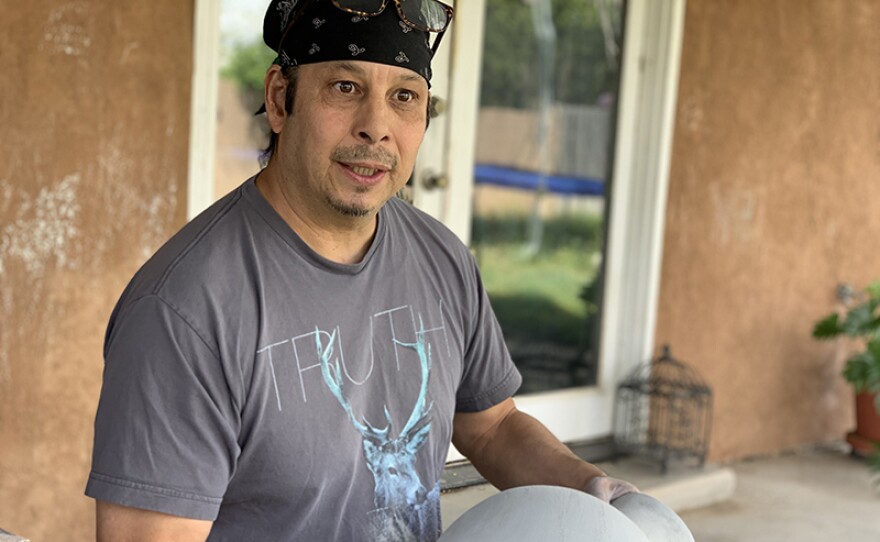 Diego Romero sanding a vessel.