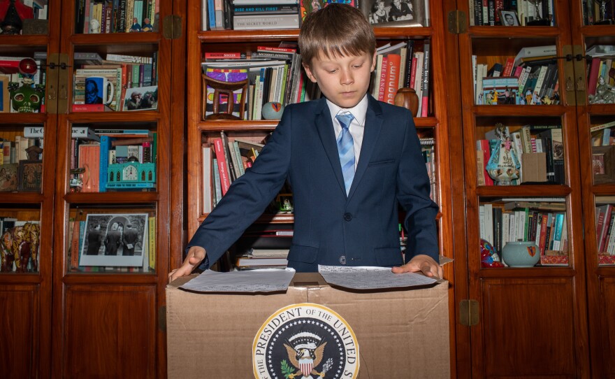 Ben, 10, revises his notes on the Gettysburg Address from a presidential cardboard podium.