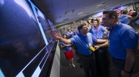 Christopher J. Scolese, Director of NASA's Goddard Space Flight Center, left, congratulates, MSL Entry, Descent and Landing Engineer Adam Steltzner as they look at the first images of Mars to come from the Curiosity rover, shortly after it landed on Mars, inside the Spaceflight Operations Facility for NASA's Mars Science Laboratory Curiosity rover at Jet Propulsion Laboratory on August 5, 2012 in Pasadena, California. 