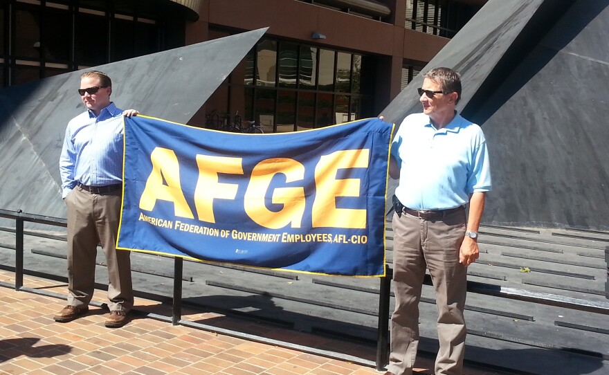 Members of the American Federation of Government Employees hold an AFGE banner during a press conference on sequestration.