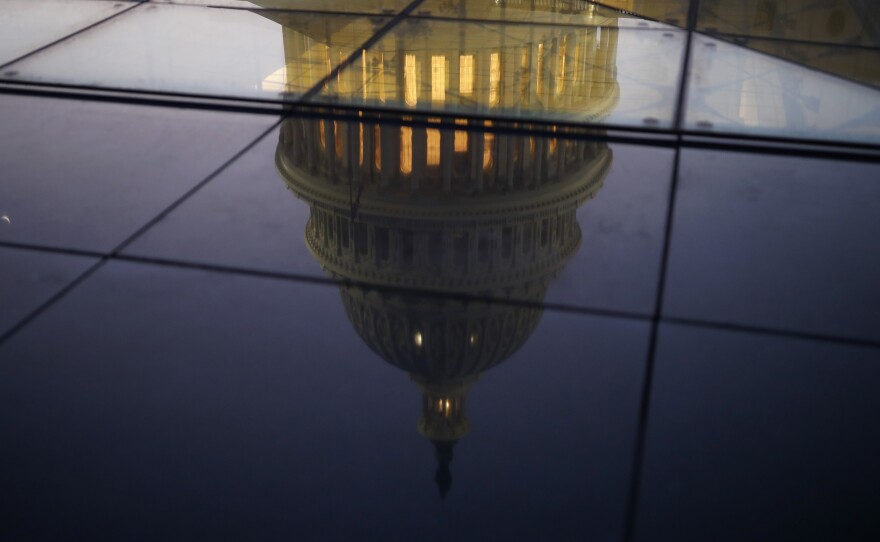 The U.S. Capitol is seen reflected in the windows of the Capitol Visitors Center as lawmakers worked to avert a government shutdown on Friday in Washington, D.C.