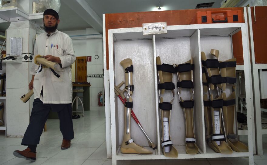 The Taliban say the Red Cross may resume its work in Afghanistan, more than five months after threatening the group. In this photo from March, an orthopedic technician walks past artificial limbs in a workshop at the International Committee of the Red Cross hospital for war victims and the disabled in Kabul.