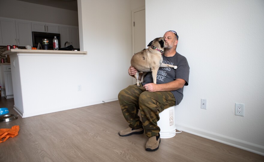 Bill Beem takes a break with his dog Wiggles while moving into his new apartment in San Diego, May 28, 2022.