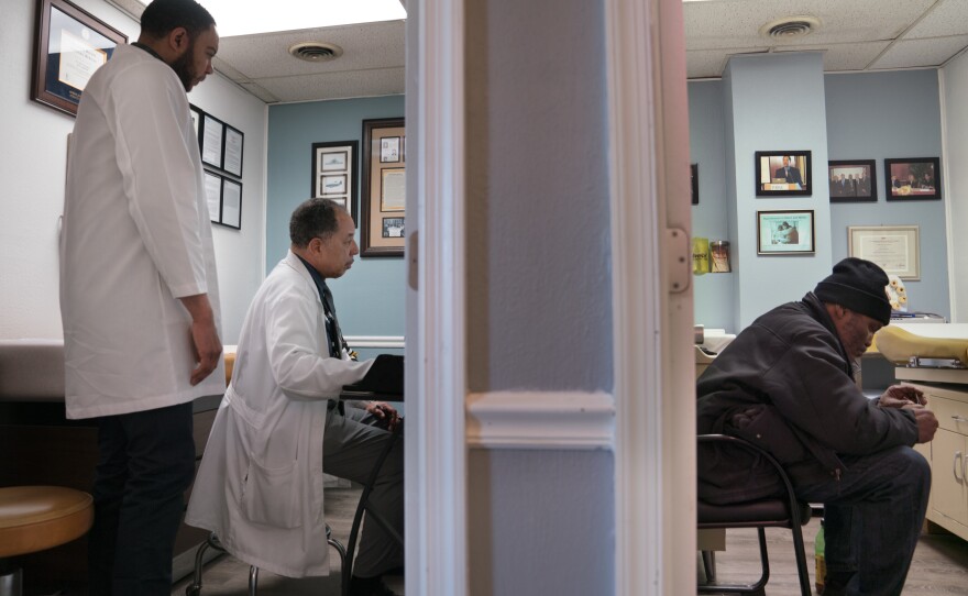 Dr. Scott Whetsell (left) is training with Chapman to better understand how to help the patients that come to the clinic. Gerald A. Goines Sr. (right) waits to see Chapman.