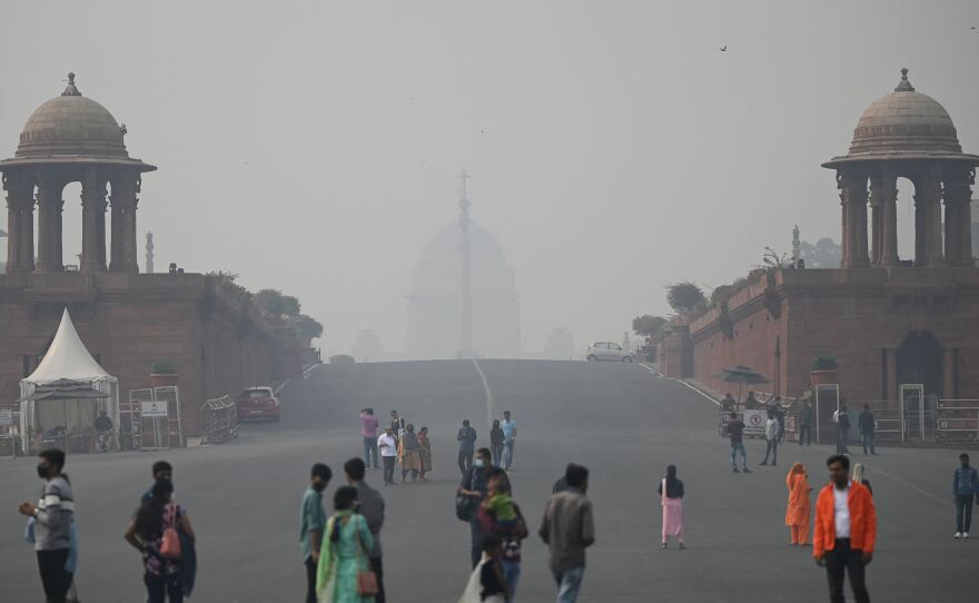 Visitors walk along the Raisina Hills at Rajpath amid smoggy conditions in New Delhi on Thursday.