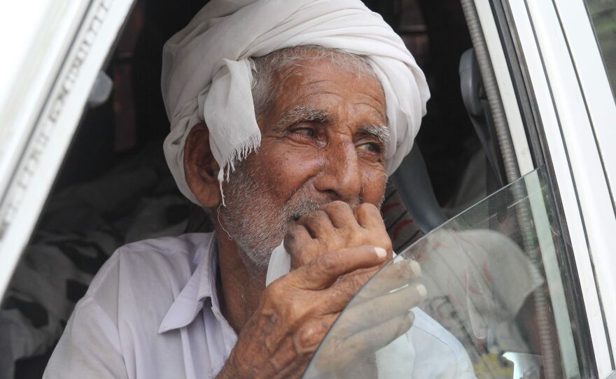 Muhammad Azeem, Qandeel Baloch's father, sits in an ambulance carrying the body of his daughter on July 17. He has called for his son to be punished for committing the murder.